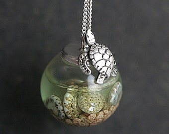 Sterling schildpad zeewater ketting. Schildpad zittend op een glazen bol gevuld met zeewater, schelpen en zand. Unieke sieraden voor haar.