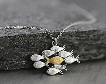 Swimming against the current silver necklace. School of fish with one golden fish swimming upstream. Necklaces for women. Gifts for mom.