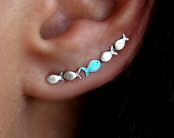 Against The Current ear climber. Against the tide with one blue turquoise fish swimming upstream. Sterling silver fish earrings.