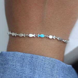 Pulsera de plata Nadando contra la corriente. Banco de peces con uno esmaltado en azul nadando contra la corriente. Joyas únicas para ella. imagen 3