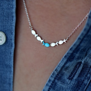 Against the current. Dainty silver necklace. Against the tide with one blue turquoise fish swimming upstream. Womens necklace.