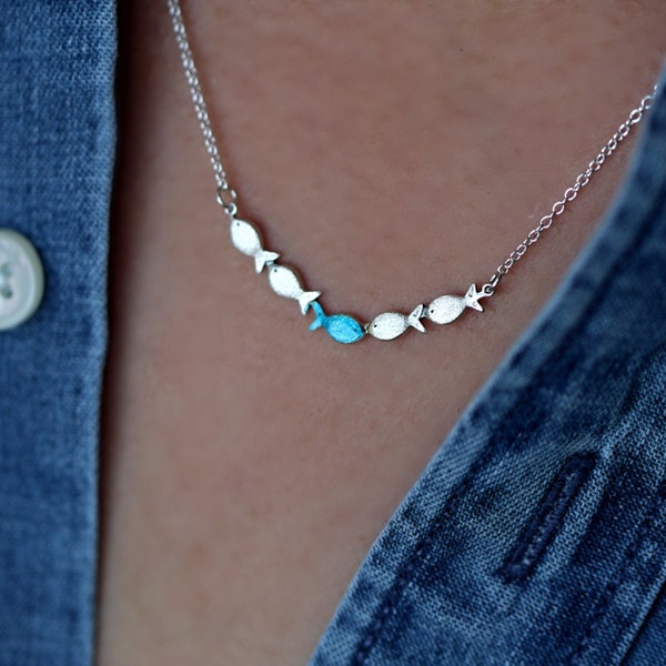 Tegen de stroom in. Sierlijke zilveren ketting. Tegen de stroom in met één blauw turquoise vis die stroomopwaarts zwemt. Dames ketting.