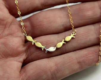 Swimming against the current. Dainty 18k necklace. School of fish with one silver fish swimming upstream. Sterling silver gold plated.