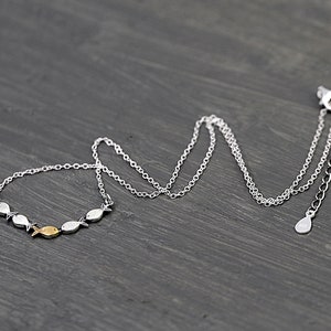 Against the current. Dainty silver necklace. Against the tide with one golden fish swimming upstream. School of fish necklace for her. image 5