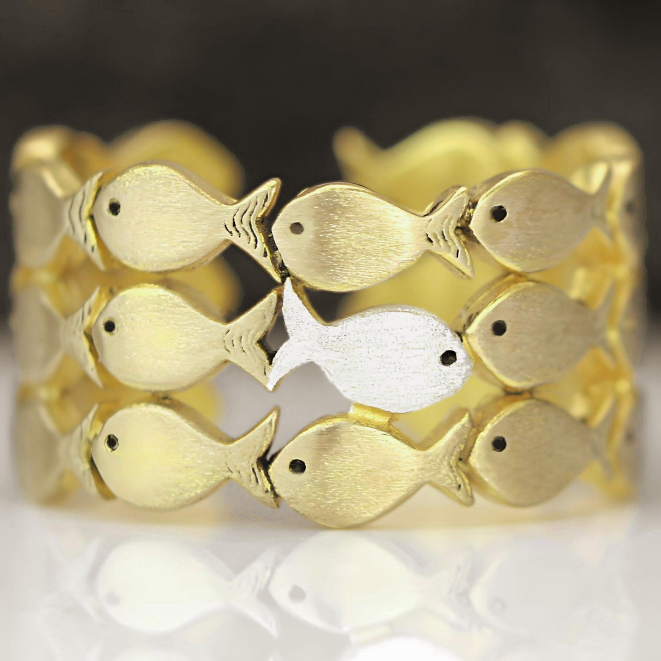 Nadando contra a corrente. Anel ajustável em ouro de lei. Cardume de peixes com um peixe prateado nadando contra a corrente. Ótimos presentes para ela.