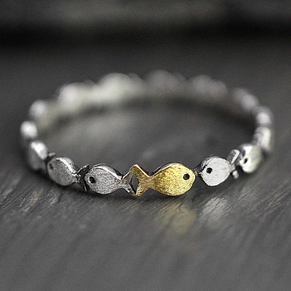 Gegen den Strom. Zarter schmaler Sterling Silber Ring. Fischschwarm mit einem goldenen, der stromaufwärts schwimmt. Geschenk für sie