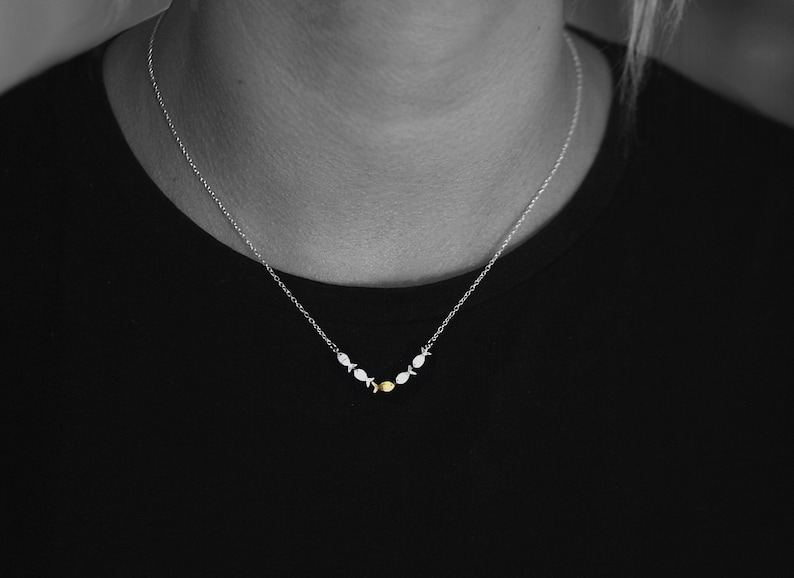 Swimming against the current. Dainty silver necklace. School of fish with one golden enameled fish swimming upstream. Gift for her. immagine 7