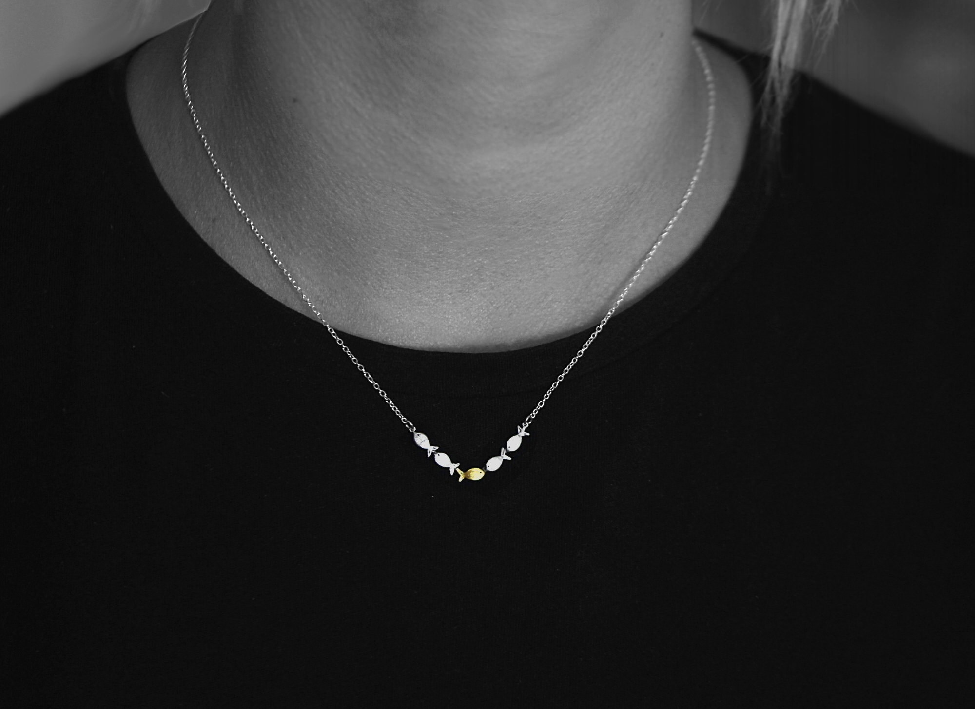 Swimming against the current. Dainty silver necklace. School of fish with one golden enameled fish swimming upstream. Gift for her.