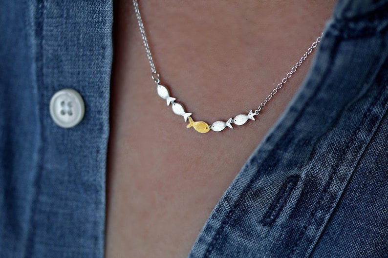 Against the current. Dainty silver necklace. Against the tide with one golden fish swimming upstream. School of fish necklace for her. image 1