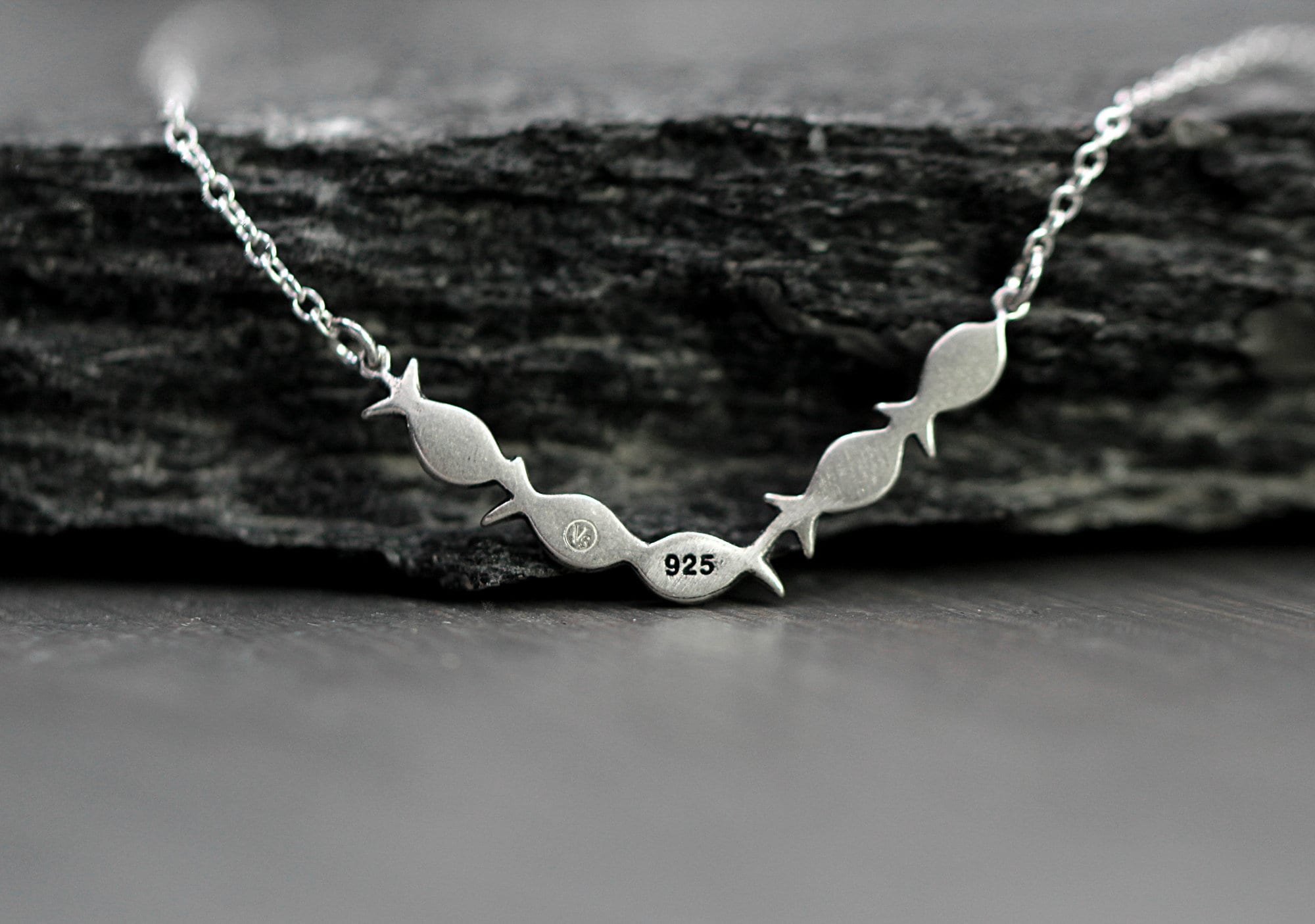 Swimming against the current. Dainty silver necklace. School of fish with one golden enameled fish swimming upstream. Gift for her.