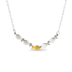 May include: A silver necklace with a row of five fish charms. The fish in the center is gold.