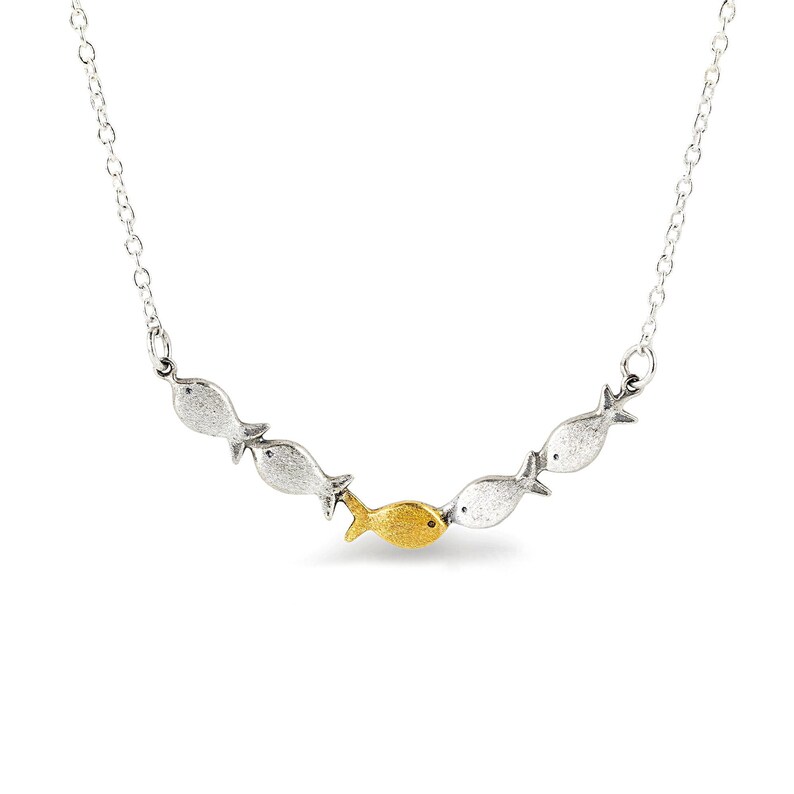 May include: A silver necklace with a row of five fish charms. The fish in the center is gold.
