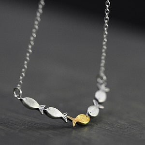 Swimming against the current. Dainty silver necklace. School of fish with one golden enameled fish swimming upstream. Gift for her. image 3