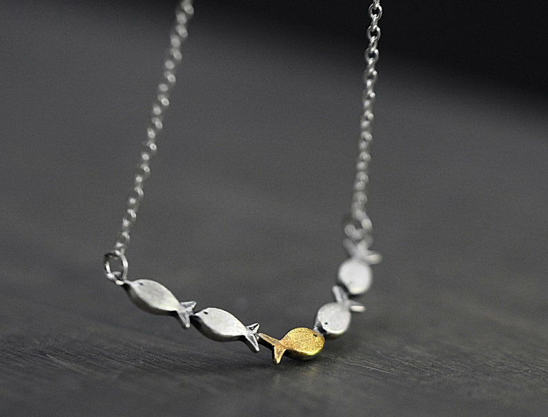 Swimming against the current. Dainty silver necklace. School of fish with one golden enameled fish swimming upstream. Gift for her. image 3