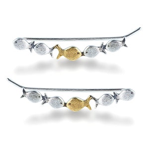May include: A pair of silver ear climbers with a row of five fish charms. The fish charms are silver except for one gold fish charm in the center.