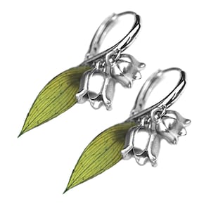 May include: Silver hoop earrings with a cluster of three lily of the valley flowers and a green leaf charm.