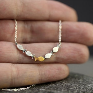 Swimming against the current. Dainty silver necklace. School of fish with one golden enameled fish swimming upstream. Gift for her. immagine 4