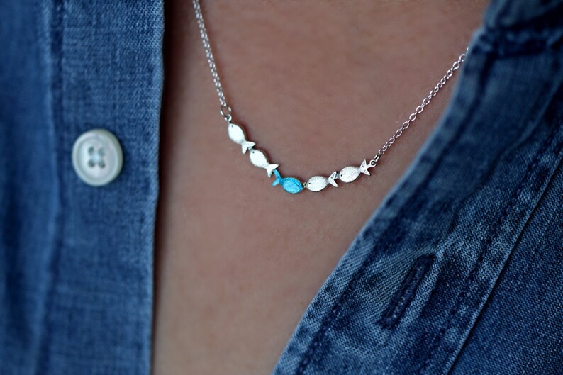 Against the current. Dainty silver necklace. Against the tide with one blue turquoise fish swimming upstream. Womens necklace. image 1