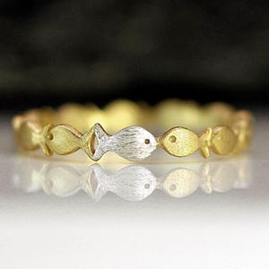 Swimming against the current. Dainty silver gold ring. School of fish with a silver one swimming upstream. Gift for her.