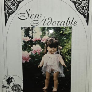May include: A doll wearing a white lingerie set, standing in front of pink flowers. The image is from a sewing pattern titled "Sew Adorable" and includes the text "Lingerie Wardrobe fits 18" dolls".