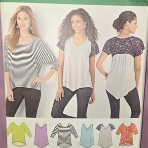 May include: A Simplicity sewing pattern envelope 1463 featuring illustrations of various top designs. The front shows three variations of shirts, including a black and white striped top and a grey top with dark lace sleeves, with size range XXS-XXL.