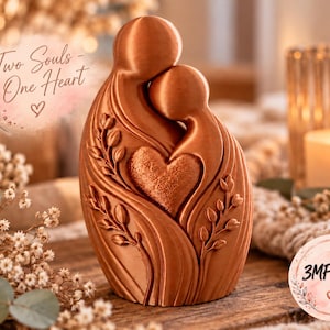May include: A copper-colored sculpture depicting two abstract figures embracing, with a textured heart at the center and floral vine details. The text "Two Souls - One Heart" and "3MF & STL" are visible in the image, along with a small heart icon.