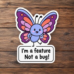 May include: A die-cut sticker featuring a cartoon butterfly with purple, pink, and light blue wings. The butterfly has a light blue body, a smiling face, and two antennae. Below the butterfly is a white rectangular speech bubble with the black text: I'm a feature Not a bug!