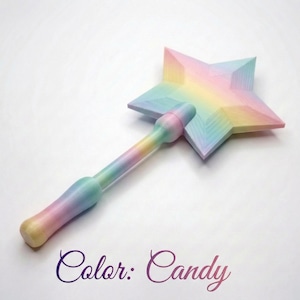 Könnte beinhalten: Ein pastellfarbener Zauberstab in Sternform mit rundem Griff. Der Zauberstab weist einen Farbverlauf auf, darunter Rosa, Gelb, Blau und Grün. Der Text "Color: Candy" ist in kursiver Schrift am unteren Bildrand geschrieben.