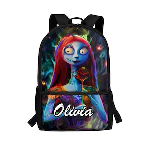 May include: A black backpack featuring a colorful graphic of a blue-skinned character with long red hair holding a red rose. The character has visible stitches on the face and neck. The name Olivia is printed in white script on the front pocket.