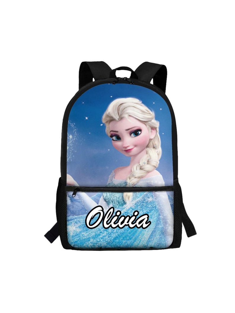 Puede incluir: Una mochila negra con un gr&aacute;fico impreso de un personaje rubio con una trenza lateral y un vestido azul claro sobre un fondo azul estrellado. El nombre Olivia est&aacute; impreso en letras blancas con un borde negro en el bolsillo delantero.