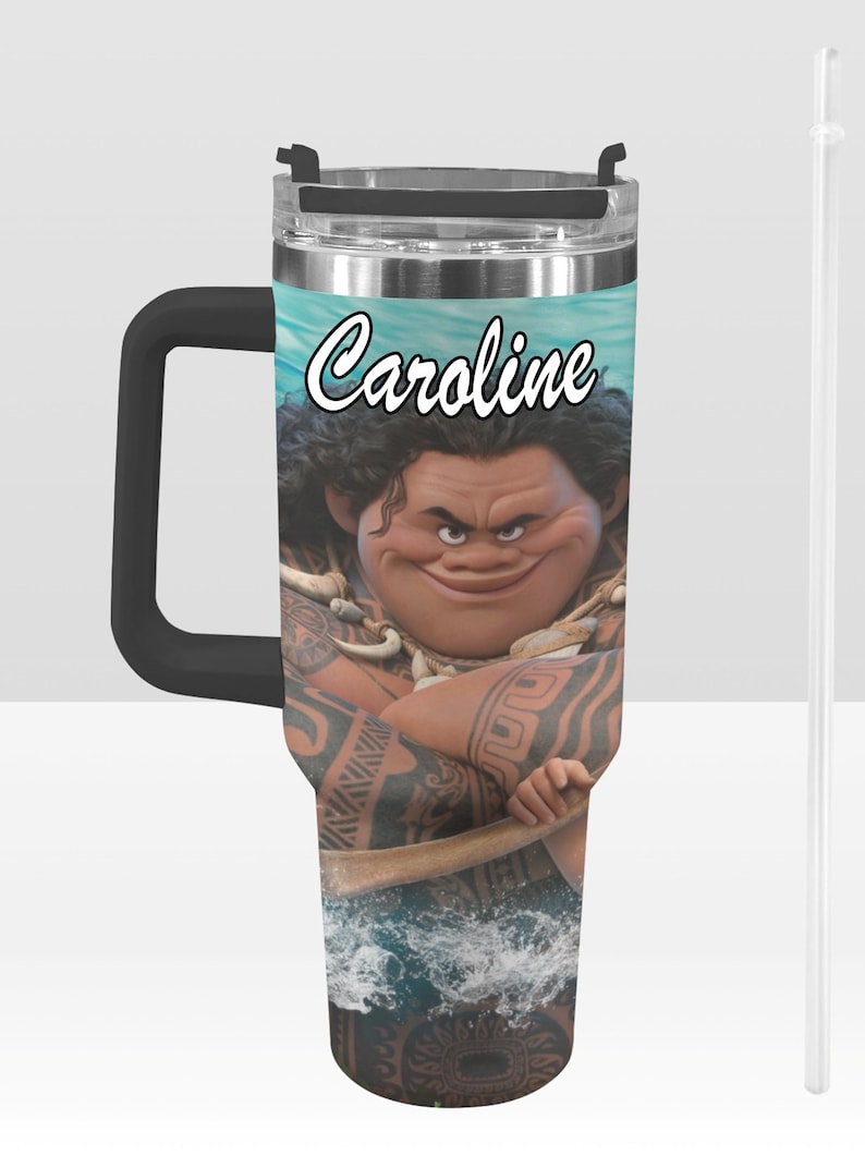 May include: A stainless steel tumbler with a black handle and a clear straw. The tumbler features a cartoon image of a character with tattoos and the name "Caroline" in white script. The background shows a blue ocean scene.