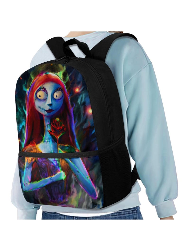 May include: A black backpack featuring a vibrant, colorful graphic print of a blue-skinned character with long red hair holding a single red rose. The backpack has black straps, a zippered main compartment, and a front pocket with a black zipper.