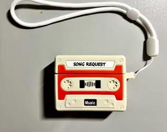 May include: A white and red cassette tape-shaped case with the text "SONG REQUEST" and "Music". The case has a white lanyard attached. The case is designed to hold small electronic devices.