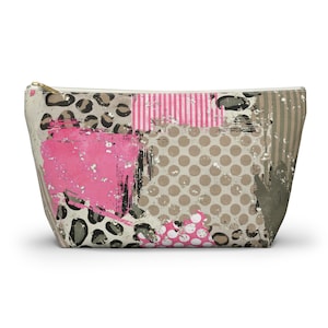 May include: A rectangular cosmetic bag with a gold zipper. The bag features a collage design with pink, beige, and gray patches. The patches include leopard print, polka dots, stripes, and brushstroke textures.