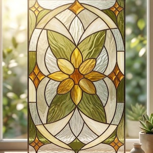 Puede incluir: Un panel rectangular de vidrieras con un diseño floral. La obra de arte incorpora una flor amarilla central, rodeada de formas de hojas verdes y blancas. Acentos de ámbar y vidrio transparente completan el diseño, enmarcado por un borde oscuro y suspendido por una cadena.