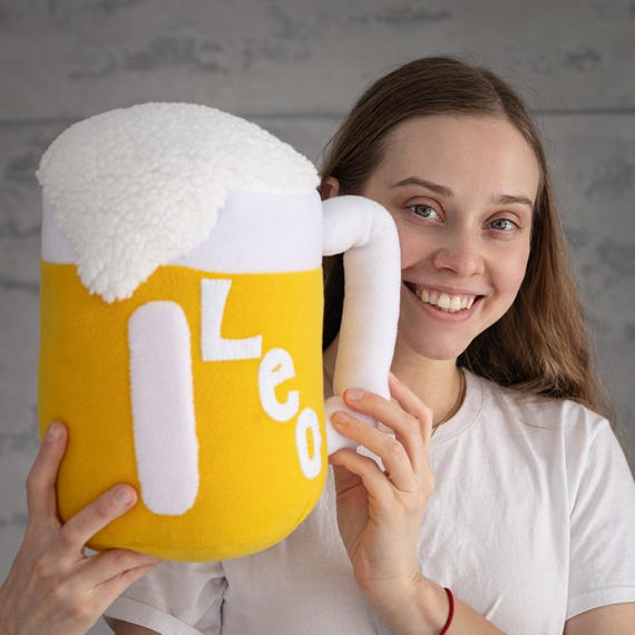 An 11-inch huggable beer stein pillow-plush — the kind of absurd man-cave accent that immediately gets a reaction.
