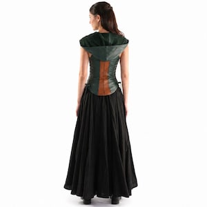 May include: A dark green hooded bodice featuring a vertical brown leather-like panel down the center back, paired with a long, flowing black skirt. The bodice includes side lacing details and a hood, creating a layered ensemble with a full-length skirt.