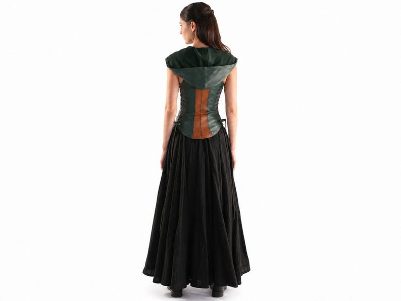 May include: A dark green hooded bodice featuring a vertical brown leather-like panel down the center back, paired with a long, flowing black skirt. The bodice includes side lacing details and a hood, creating a layered ensemble with a full-length skirt.