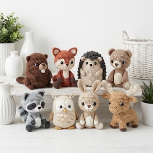 May include: A collection of handmade crochet woodland animal toys, including a beaver, fox, hedgehog, bear, raccoon, owl, bunny, and moose. Each animal is crafted with detailed features and various colors, perfect for children's play or nursery decor.