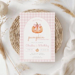 May include: A rectangular birthday invitation card featuring a light pink and white gingham border. The center displays an arched white panel with a watercolor pumpkin wearing a pink bow, text reading Our Little Pumpkin Is Turning One, Christine's 1st Birthday, June 10 at 10:00 AM, The Willow Garden, 123 Maple St., Brooklyn, and RSVP details.
