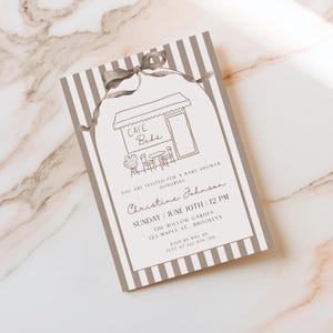 May include: A rectangular baby shower invitation card featuring a brown and white vertical striped border and a hand-drawn illustration of a cafe with the text CAFÉ BEBÉ. The card includes event details for Christine Johnson on June 10th at 12 PM.