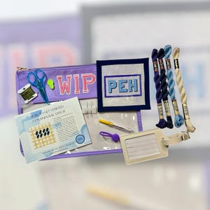 May include: A purple WIP (Work in Progress) project bag with scissors, thread, and a needlepoint canvas with the letters PEH. Includes embroidery floss in shades of blue and cream, a pen, and a luggage tag.