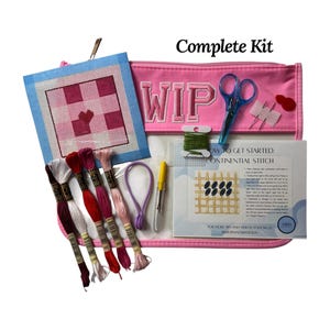 May include: A complete needlepoint kit with a pink zippered pouch labeled "WIP". Includes scissors, needles, thread, and a canvas with a checkered design. The kit also contains instructions for the continental stitch.