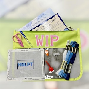 May include: A lime green zippered pouch labeled "WIP" in pink letters, filled with needlepoint supplies. Includes scissors, a pen, thread, a needlepoint canvas with "NDLPT" stitched, and instructional papers. The pouch has a clear front.