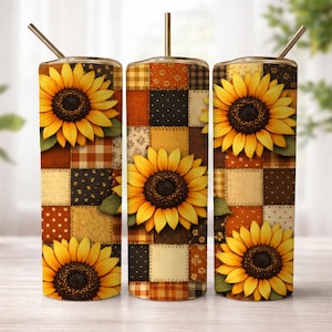 May include: Three stainless steel tumblers with sunflower designs. Each tumbler features a patchwork pattern in shades of brown, orange, and cream, with a large sunflower in the center. The tumblers have gold-colored straws.