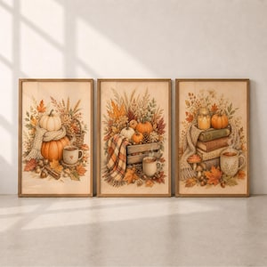 May include: A set of three vertical wall art prints featuring autumn themes. The first shows pumpkins, a knit scarf, and a mug. The second displays a wooden crate with pumpkins and a plaid blanket. The third depicts a stack of books, a mug, and leaves.