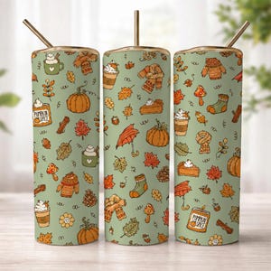 May include: Three cylindrical tumblers with straws, featuring a light green background covered in a repeating pattern of orange pumpkins, autumn leaves, jumpers, scarves, mushrooms, and cups labelled Pumpkin Spice with whipped cream toppings.
