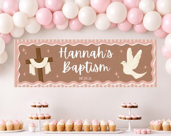 May include: A rectangular banner with a brown background and pink scalloped border featuring a wooden cross draped in white cloth, a white dove, and the text Hannah's Baptism 08.20.26, displayed beneath a cluster of pink and white balloons.