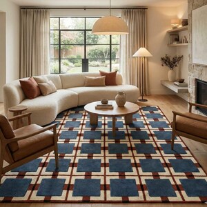 Può includere: Un soggiorno moderno con un divano curvo color crema, poltrone in pelle marrone e un tavolino rotondo in legno. Un tappeto geometrico nei toni del blu, rosso e crema copre il pavimento. Grandi finestre e una lampada a sospensione completano lo spazio.