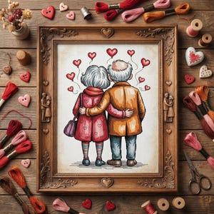 Puede incluir: Un bordado enmarcado que representa a una pareja de ancianos abrazándose, rodeados de globos con forma de corazón. El marco es ornamentado y la escena está ambientada sobre una superficie de madera con suministros de bordado, incluyendo carretes de hilo y botones en forma de corazón.